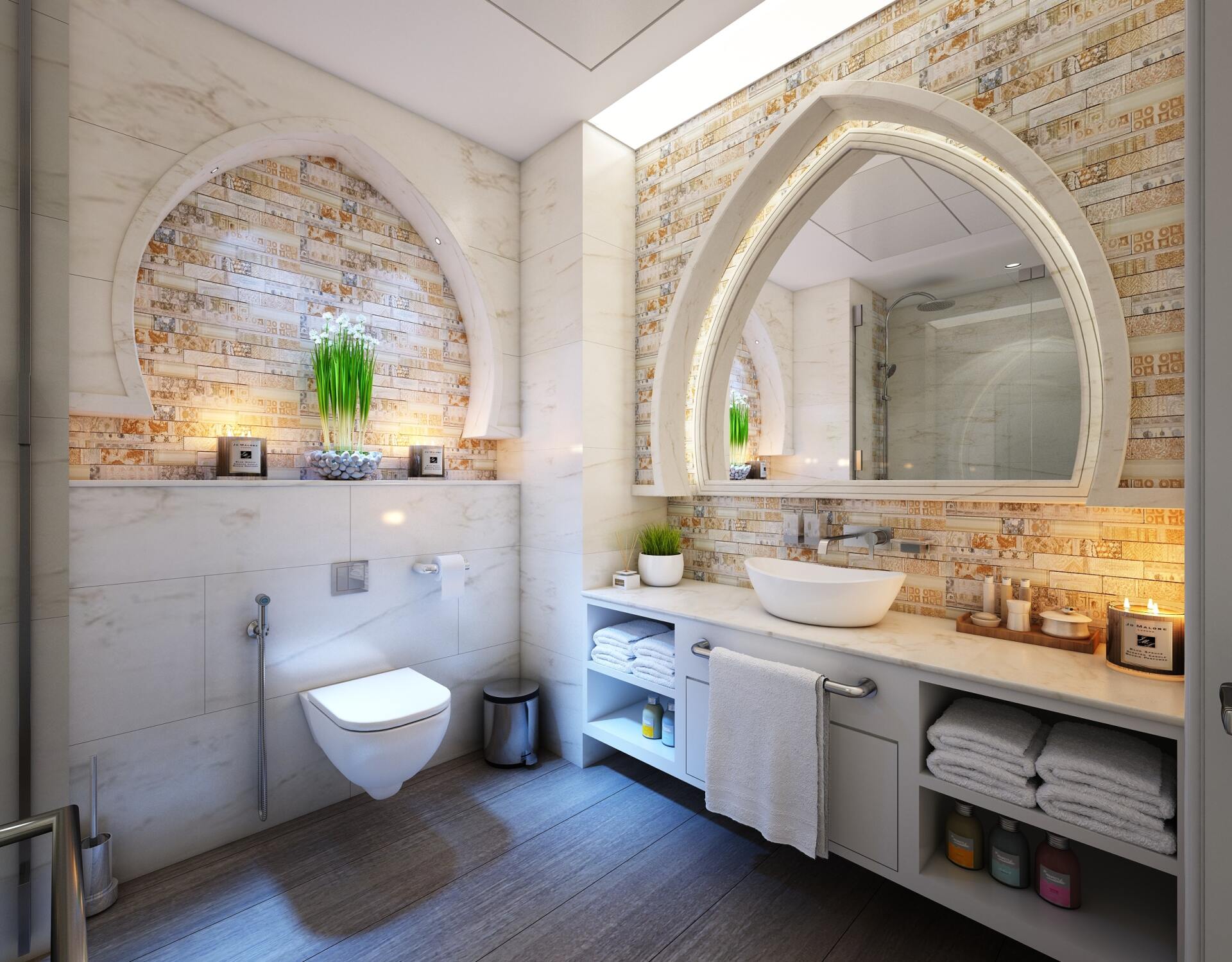 Bright modern bathroom with arched mirrors, white sink, wall-mounted toilet, and warm tile accents